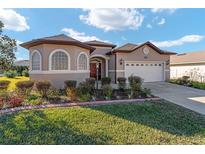 Beautiful one-story home with a two-car garage and manicured lawn at 11276 Se 170Th Pl, Summerfield, FL 34491