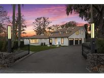 Elegant home featuring a gated entrance, black trim, and a meticulously maintained driveway at 301 Rippling Ln, Winter Park, FL 32789