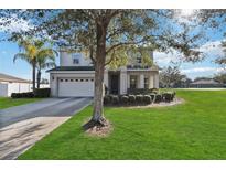 Two-story house with a large front yard and attached garage at 2016 Sanderlin Point Loop, Apopka, FL 32703