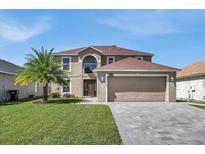 Two-story house with a large driveway and landscaped lawn at 11924 Pethrick Dr, Orlando, FL 32824