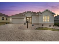 Attractive single-story home with a paved driveway and landscaping at 461 Troy Loop, The Villages, FL 32162