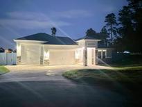 Attractive single-story home with a two-car garage and well-manicured lawn at night at 9805 Sw 44Th Ter, Ocala, FL 34476