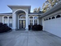 Two-story house with a gray facade, a three-car garage, and landscaping at 1150 Sweet Heather Ln, Apopka, FL 32712