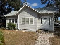 Charming bungalow exterior, freshly painted, features a walkway and well-maintained landscaping at 373 E Waldo St, Groveland, FL 34736