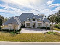 Grand home features a manicured lawn, elegant entrance, and circular brick driveway at 8570 Nw 31St Lane Rd, Ocala, FL 34482
