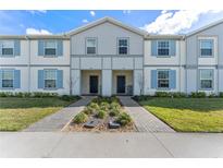 Charming townhome with blue shutters, freshly manicured lawn, and welcoming entrance at 921 Paradise Dr, Davenport, FL 33897