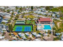 An aerial view showcases the active community with a pool, clubhouse, tennis courts, and beautiful landscaping at 9000 Us Highway 192 # 242, Clermont, FL 34714