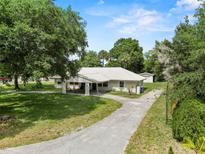 Charming home with a long driveway and lush greenery all around the property at 103 S Flagler Ave, Edgewater, FL 32132