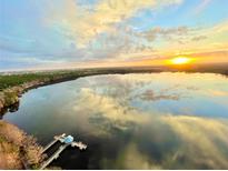Stunning sunset over the lake with a view of the dock, and the city skyline in the distance at 13427 Blue Heron Beach Dr # 2106, Orlando, FL 32821