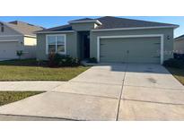 Well-maintained single-story home with a two-car garage and a neatly manicured front lawn at 357 Summershore Dr, Auburndale, FL 33823