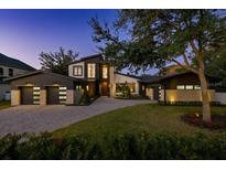 Beautiful modern two-story home with a manicured lawn, stone accents, and a spacious three-car garage at 1691 Chestnut Ave, Winter Park, FL 32789