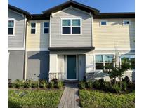 Attractive two-story townhome with neutral-colored siding, tidy landscaping, and a welcoming front entrance at 3842 Knotty Pine St, St Cloud, FL 34772