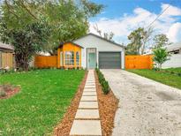 Charming home featuring a well-manicured lawn, inviting walkway, and an attached one car garage at 748 Neuse Ave, Orlando, FL 32804
