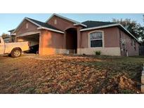 Exterior elevation of single story house with stucco siding, a garage, and a well maintained front lawn at 30126 Sandbunker Ln, Sorrento, FL 32776