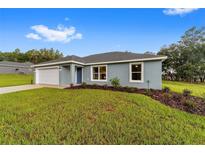 Charming single-story home showcasing a well-manicured lawn, modern windows, and a cozy, inviting facade at 15673 Sw 37 Cir, Ocala, FL 34482