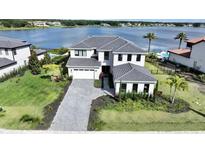 Stunning two-story home with meticulously landscaped yard and a driveway leading to a spacious two-car garage at 16832 Bolsena Dr, Bella Collina, FL 34756