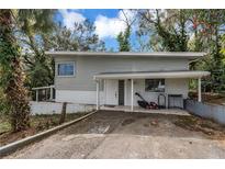 View of the home's exterior with lawnmower parked on the front porch and driveway in front at 1630 Lakeview Ct, Eustis, FL 32726