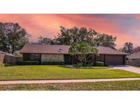 Charming single-story home featuring a stone accent wall, mature landscaping, and a well-maintained lawn at 1506 Grace Lake Cir, Longwood, FL 32750