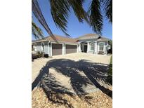 Beautiful single-story home boasts a three-car garage and manicured front yard with tropical landscaping at 3345 Tesoro Cir, New Smyrna Beach, FL 32168