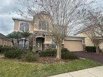 Charming two-story home featuring a stone facade, a two-car garage and manicured landscaping at 1678 Swallowtail Ln, Sanford, FL 32771