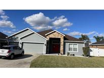 Charming single-story home with gray siding, stone accents, and a well-manicured lawn at 2822 Seymore St, Lakeland, FL 33813