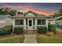 Charming single-story home featuring a cozy porch, well-maintained landscaping, and a welcoming facade at sunset at 501 Washington Ave, Eustis, FL 32726