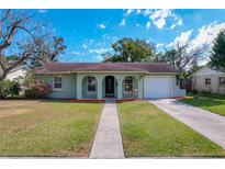 Charming single-story home with a well-manicured lawn and inviting front porch at 5619 Pinerock Rd, Orlando, FL 32810