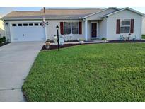 Charming single-story home boasts a well-manicured lawn and attached two-car garage at 3405 Forsythe Ter, The Villages, FL 32162
