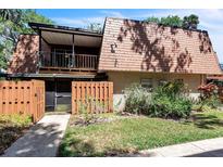 Two-story home with brick facade, balcony, fenced entry, and mature landscaping at 159 Sweetgum Ln, Port Orange, FL 32129