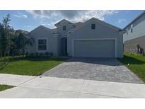 Charming single-story home featuring a gray exterior, well-maintained lawn, and a two-car garage at 4910 Lyric Dr, Mascotte, FL 34753
