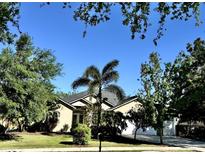 Charming single-story home surrounded by lush landscaping and mature trees, offering great curb appeal at 9632 Spring Lake Dr, Clermont, FL 34711