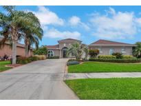 Beautiful single-story home featuring a well-manicured lawn, lush landscaping, and a long driveway leading to the front entrance at 508 Bacio St, New Smyrna Beach, FL 32168
