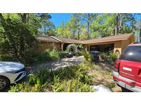 Exterior shot of the home with mature landscaping and an arched entrance at 20045 Sw 88Th Place Rd, Dunnellon, FL 34431