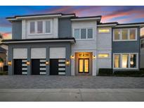 Stunning two-story home with modern design, three-car garage, and beautifully landscaped front yard at 1514 Corolla Ct, Reunion, FL 34747