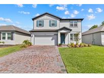 Charming two-story home featuring a brick driveway, attached garage, and professionally landscaped front yard at 3153 Legends Preserve Dr, Daytona Beach, FL 32124
