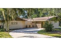 Charming single-story home with a long driveway and mature landscaping at 246 Ridge Manor Dr, Lake Wales, FL 33853