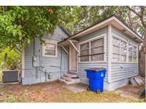 Back of the house with weathered siding, small porch with white door, and blue recycling bin at 515 New York Ave, St Cloud, FL 34769