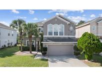 Charming two-story home featuring stone accents, a manicured lawn, and a two-car garage at 13532 Meadow Bay Loop, Orlando, FL 32824
