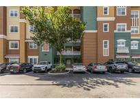 Well-maintained condo exterior with colorful facade, balconies and parking lot for residents at 8749 The Esplanade # 6, Orlando, FL 32836