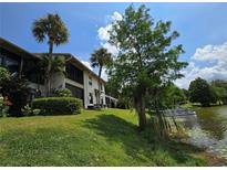 Scenic exterior view of lakeside home with lush landscaping and mature palm trees at 200 Maitland Ave # 114, Altamonte Springs, FL 32701