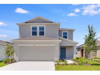 Charming two-story home showcasing a neutral color palette, well-manicured lawn, and an attached two-car garage at 5133 Forget Me Not Ave, Lake Hamilton, FL 33851