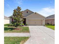 Charming single-story home featuring a well-maintained lawn and attached two-car garage at 224 Nova Dr, Davenport, FL 33837