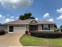 Charming single-story home with a well-manicured lawn and a two-car garage at 17430 Se 110Th Ter, Summerfield, FL 34491