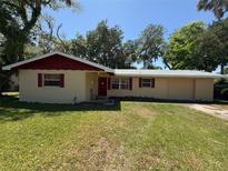 Charming one-story home with a well-maintained lawn and mature trees providing ample shade at 1818 Mango Tree Dr, Edgewater, FL 32132