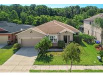 Charming single-story home featuring a well-maintained lawn, mature landscaping, and an attached two-car garage at 2960 Boating Blvd, Kissimmee, FL 34746