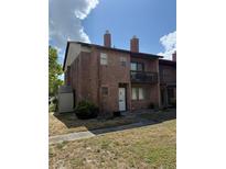 Brick condo features a quaint balcony, side shed, and an unfinished front yard at 5032 Downing St # 10, Orlando, FL 32839
