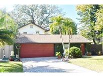 Charming home featuring an attached two-car garage, well-maintained landscaping, and mature palm trees at 1823 Sunset Dr, Winter Park, FL 32789