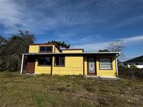 Charming yellow single-Gathering home with brown trim and a well-lit front yard at 1925 Laredo Dr, Deltona, FL 32738