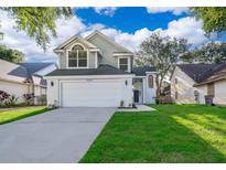 Charming two-story home showcasing a well-manicured lawn and an attached two-car garage at 1839 Cranberry Isles Way, Apopka, FL 32712