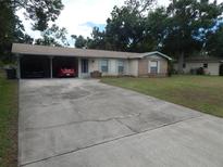 Single Gathering home with driveway and car port, blue shutters, brick accent and mature landscaping at 3509 Lisa Ln, Lakeland, FL 33801